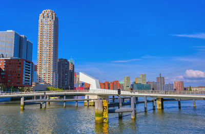 View of river and buildings against blue sky