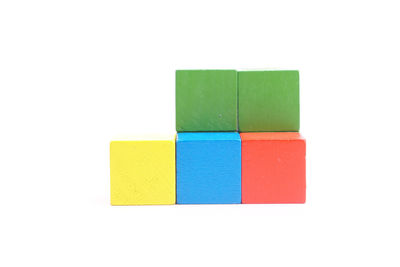 Stack of multi colored toy against white background