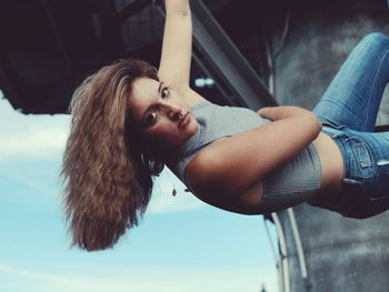 Portrait of young woman with arms raised