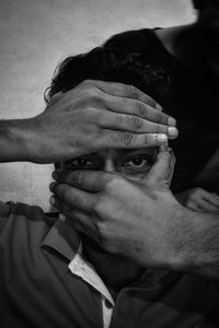 Close-up portrait of man covering face with hands