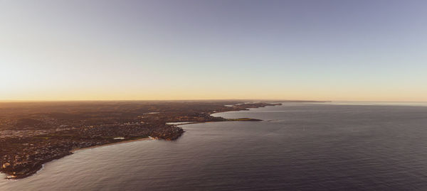 Scenic view of sea against clear sky during sunset