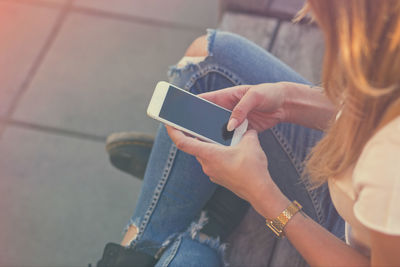 Midsection of woman using mobile phone