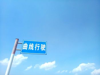 Low angle view of road sign against sky