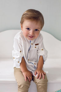 Child sitting on a wooden white cart in the studio as a birthday decoration