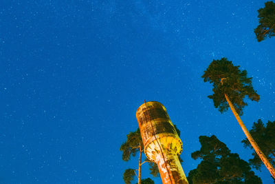 Low angle view of trees against clear blue sky