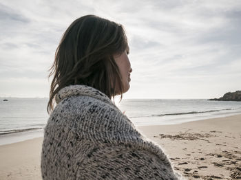 Side view of woman against sky at beach