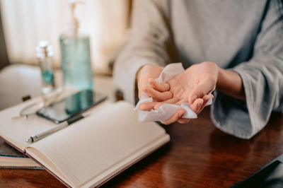 Midsection of woman reading book on table