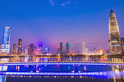 Illuminated buildings by swimming pool at night