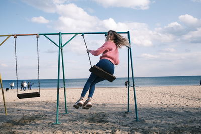 Rear view of woman swinging at playground