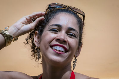 Close-up of a woman against orange background on the street. 