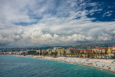 Scenic view of sea by buildings against sky