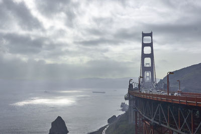 View of bridge over sea against cloudy sky