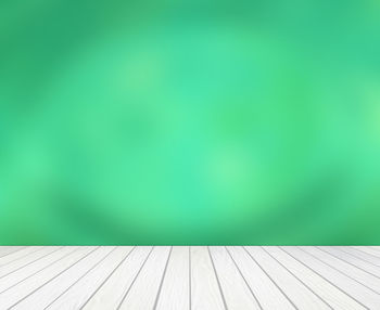Abstract image of empty green hardwood floor against wall
