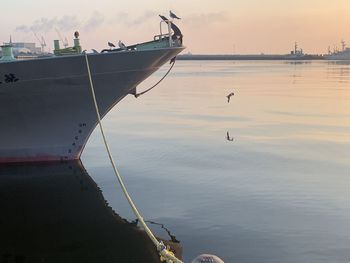 Sailboats moored in sea against sky