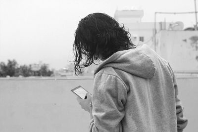 Man in hooded shirt using phone