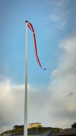 Low angle view of red flag against sky