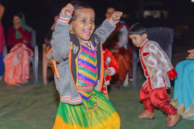 Cheerful girl dancing on field at night