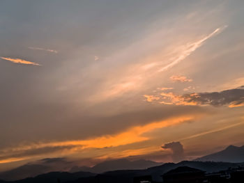 Low angle view of silhouette mountains against dramatic sky