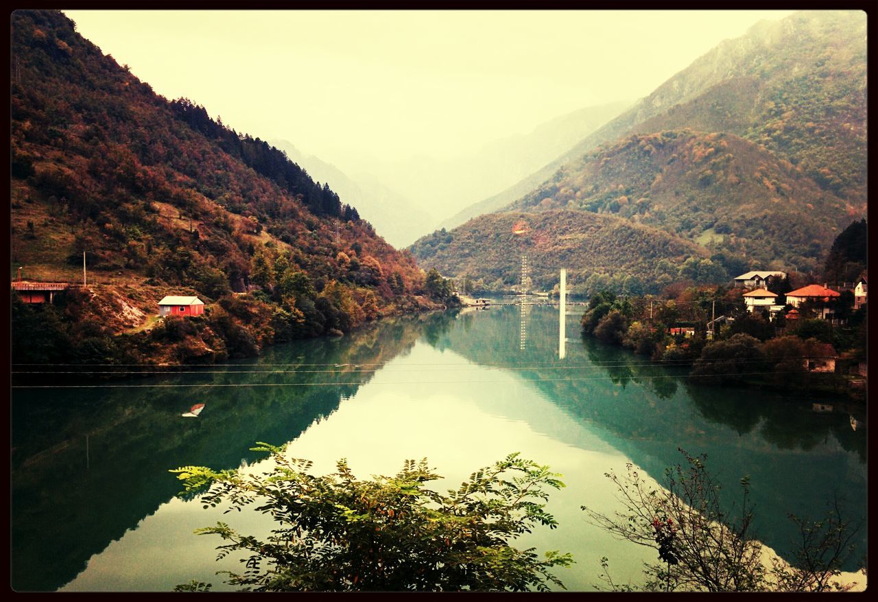 mountain, water, transfer print, tree, lake, reflection, scenics, tranquil scene, tranquility, mountain range, beauty in nature, auto post production filter, river, nature, clear sky, waterfront, idyllic, sky, day, outdoors