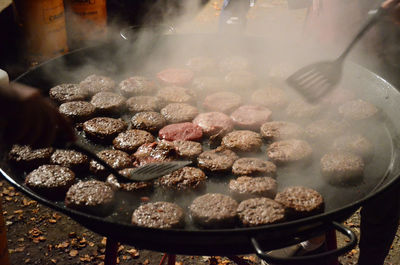 Burgers being fried in a very large pan