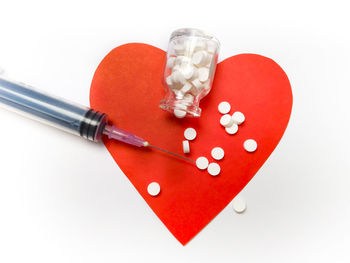 High angle view of heart shape glass on table against white background