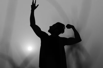 Low angle view of silhouette man posing against clear sky