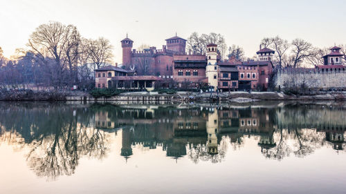 Reflection of buildings on river against sky