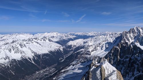 Scenic view of snowcapped mountains against blue sky