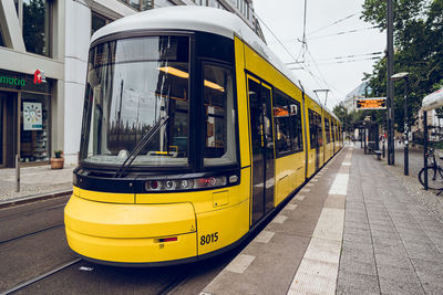Yellow cable car on road in city