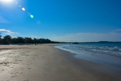 Scenic view of beach against blue sky