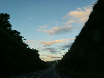 Road amidst trees against sky