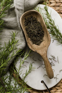 Dried rosemary in wooden scoop