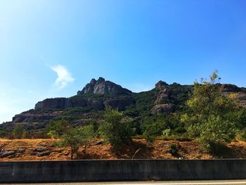 Low angle view of mountain against blue sky