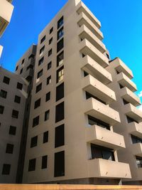 Low angle view of modern building against clear blue sky