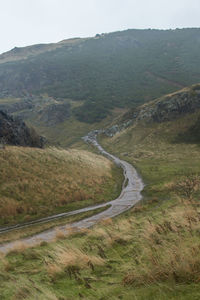 Scenic view of road by mountains against sky