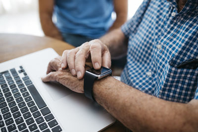 Senior man using smartwatch, close-up