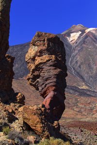 Rock formation on mountain against clear blue sky