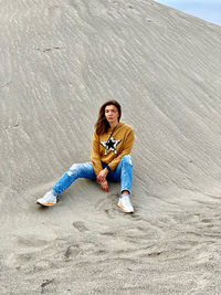 Portrait of smiling young woman sitting on land