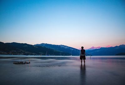 Full length of man on lake against clear sky