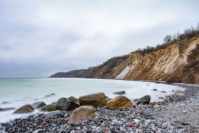 Rocks in sea against sky