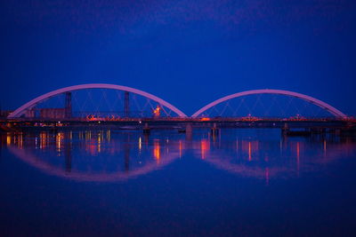 Arch bridge over river against sky at night