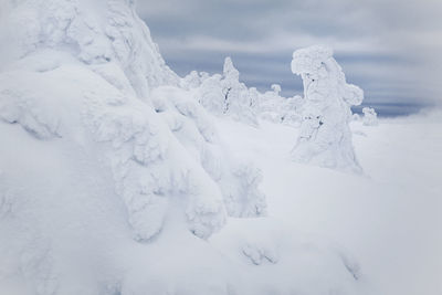 Snow covered landscape against sky