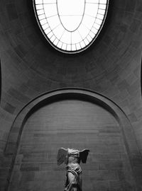 Low angle view of person standing on ceiling