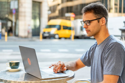 Man using mobile phone on table in city