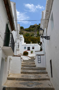 Low angle view of staircase amidst buildings against sky