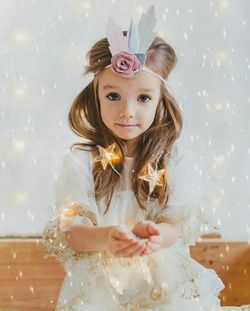 Portrait of girl wearing princess costume holding illuminated star shape