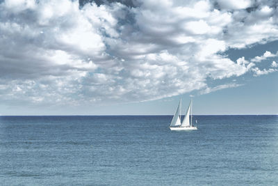 Sailboat sailing on sea against sky