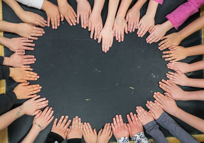 High angle view of people making heart shape from hands