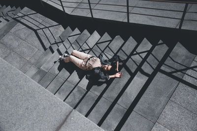 High angle view of woman lying down on staircase