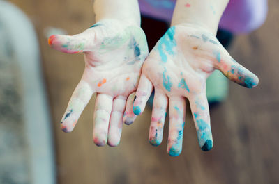 Low section of child hand covered with powder paint